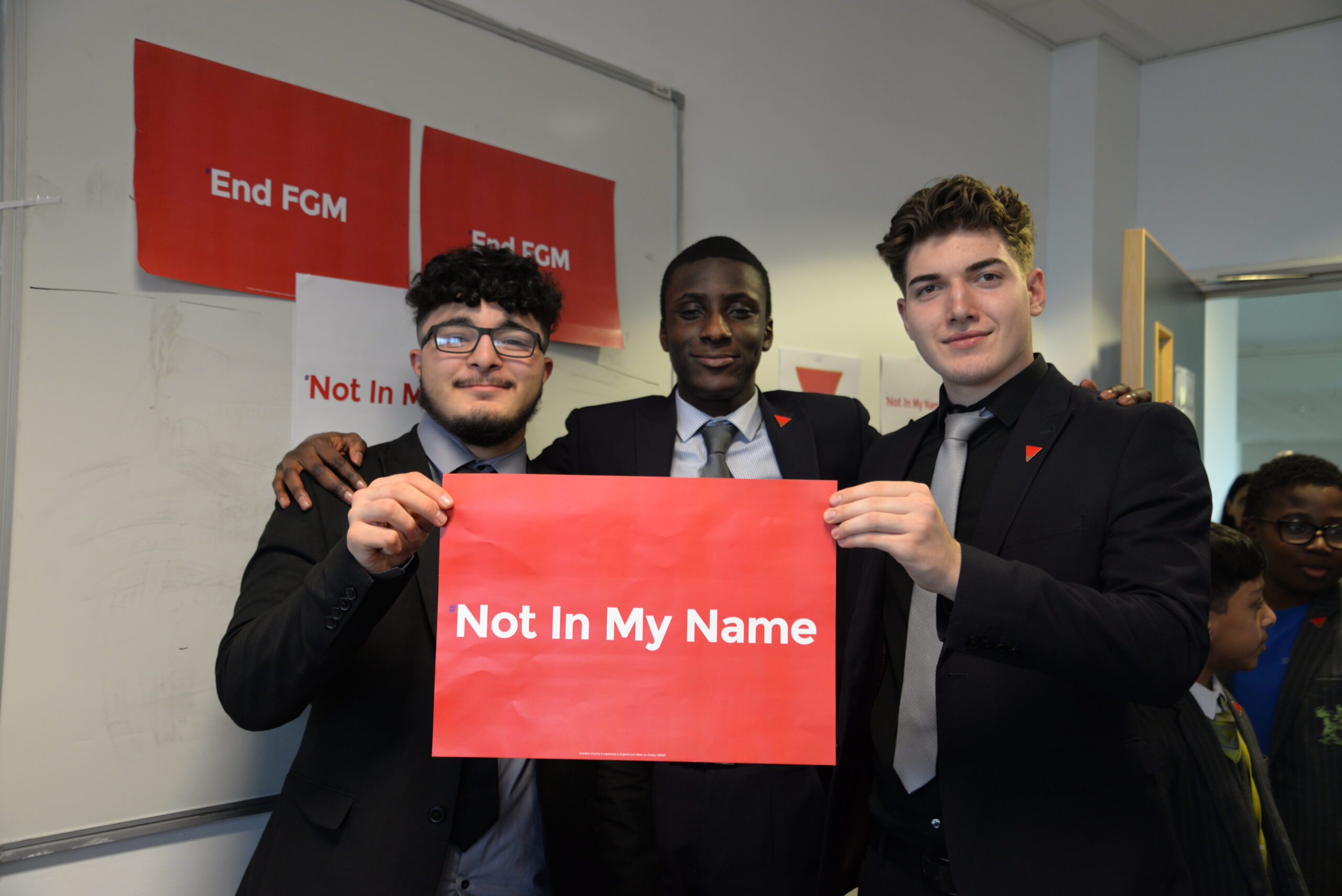 Group of young men holding Freedom Charity Not in My Name campaign signs