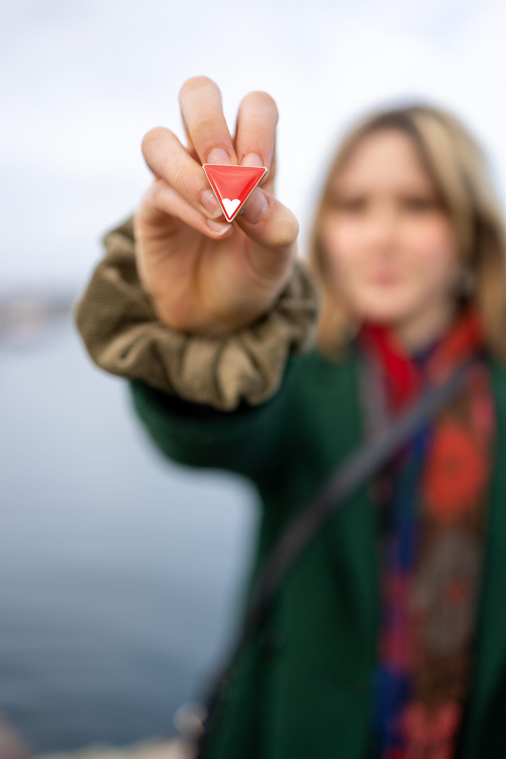 Original Freedom Charity photograph of a young person holding the Red Triangle badge against FGM